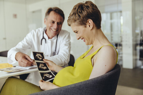 Schwangere Frau im Gespräch mit ihrem Arzt über Ultraschalluntersuchungen - MFF04471