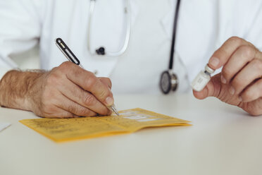 Doctor filling in immunization card - MFF04478