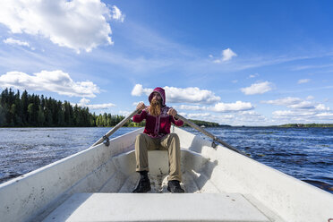 Finnland, Mann rudert in einem Boot auf einem See - KKAF01730