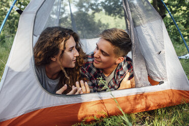 Glückliches junges Paar liegt im Zelt und unterhält sich - VPIF00616