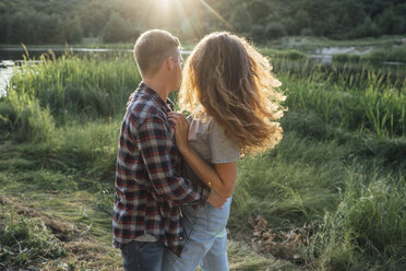 Romantic couple spending time in nature, embracing at sunset - VPIF00628