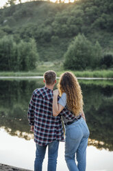 Romantic couple standing at the riverside, embracing - VPIF00635