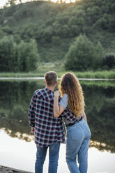 Romantisches Paar am Flussufer, das sich umarmt - VPIF00635