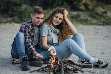 Romantisches Paar sitzt am Lagerfeuer am Flussufer - VPIF00637