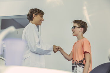 Boy greeting dentist, shaking hands - MFF04541