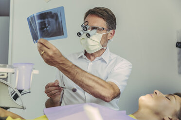 Dentist looking at x-ray image before treatment - MFF04555