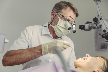 Dentist examining his patient, using dental microscope - MFF04556