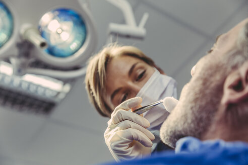 Zahnchirurg bei einem chirurgischen Eingriff an einem Patienten - MFF04571