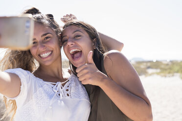 Freundinnen haben Spaß am Strand und machen Smartphone-Selfies - PACF00115