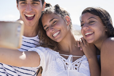 Friends having fun on the beach, taking smartphone selfies - PACF00117