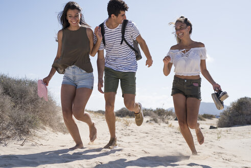 Freunde haben Spaß, laufen barfuß am Strand - PACF00119