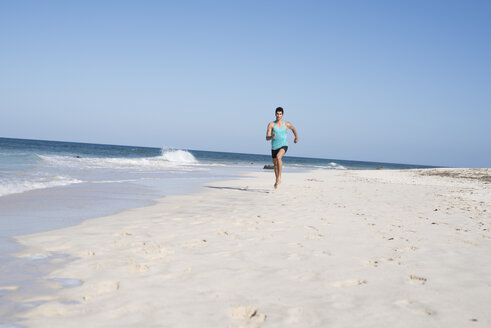 Spanien, Kanarische Inseln, Fuerteventura, junger Mann läuft am Strand - PACF00135