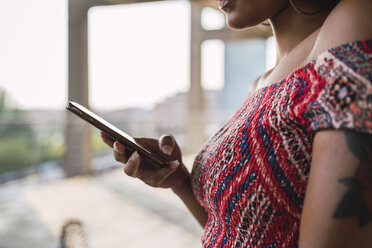 Woman using cell phone, partial view - KKAF01746