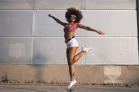 Portrait of fashionable woman jumping in the air stock photo