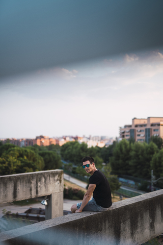 Porträt eines Mannes, der sich am Abend an einer Mauer ausruht, lizenzfreies Stockfoto