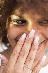 Porträt einer lachenden jungen Frau mit künstlichen Fingernägeln - KKAF01773