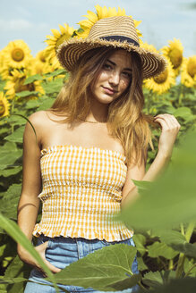 Junge Frau mit Strohhut in einem Sonnenblumenfeld - ACPF00324