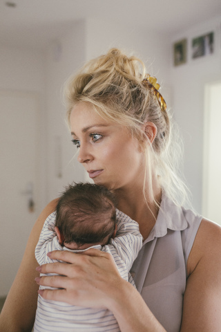 Mother holding her baby at home stock photo