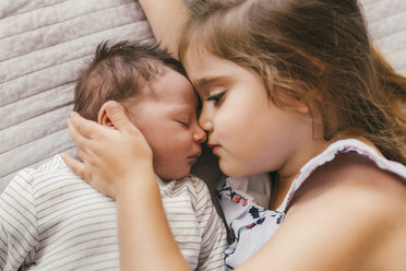 Affectionate girl lying on blanket cuddling with her baby brother - MFF04618