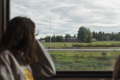 Woman traveling by train looking out of window - KKAF01785