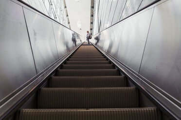 Frau auf der Rolltreppe einer U-Bahn-Station stehend - KKAF01788