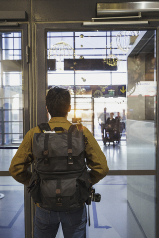 Junger Mann mit Rucksack auf dem Flughafen, lizenzfreies Stockfoto