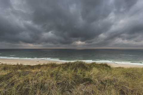 Deutschland, Schleswig-Holstein, Sylt, Wenningstedt, Regenwolken über dem Strand, lizenzfreies Stockfoto