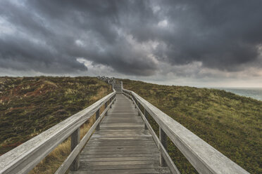 Deutschland, Schleswig-Holstein, Sylt, Wenningstedt, Uferpromenade zum Strand unter Regenwolken - KEBF00919