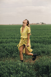 Young woman walking in a green field - ACPF00344