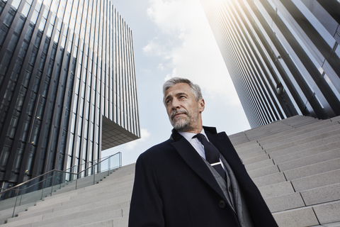 Porträt eines eleganten Geschäftsmannes vor moderner Architektur, lizenzfreies Stockfoto