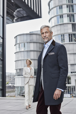 Deutschland, Düsseldorf, Porträt eines eleganten reifen Geschäftsmannes vor einem modernen Geschäftsgebäude, lizenzfreies Stockfoto