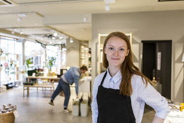 Porträt eines selbstbewussten Inhabers, der einem Kunden in einer Boutique gegenübersteht - MASF08623