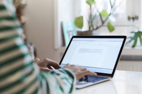 Ausgeschnittenes Bild eines Unternehmers, der einen Laptop benutzt, während er zu Hause sitzt, lizenzfreies Stockfoto