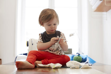 Full length of girl playing while sitting on table at home - MASF08718