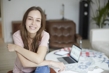 Porträt einer lächelnden Modedesignerin, die zu Hause am Tisch sitzt - MASF08748