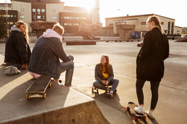 Freunde unterhalten sich in einem Skateboardpark in der Stadt an einem sonnigen Tag - MASF08809