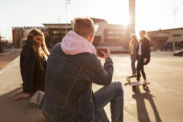 Jugendlicher fotografiert Freunde beim Skateboarden im Park - MASF08811