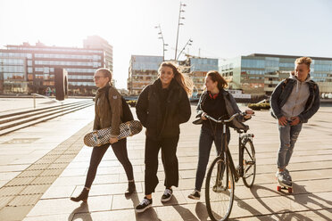 Teenager-Freunde gehen mit Fahrrad und Skateboards in der Fußgängerzone der Stadt spazieren - MASF08834