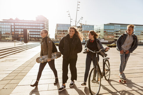 Teenager-Freunde gehen mit Fahrrad und Skateboards in der Fußgängerzone der Stadt spazieren - MASF08834