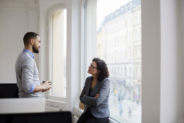 Male and female business colleagues discussing at office - MASF08865