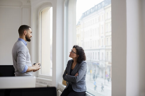 Männliche und weibliche Geschäftskollegen diskutieren im Büro - MASF08865