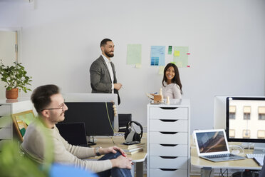 Lächelnde Geschäftskollegen bei einem Treffen im Büro - MASF08889