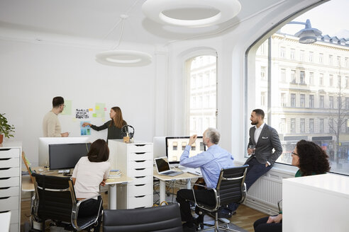 Geschäftsfrau tauscht Ideen mit männlichen und weiblichen Kollegen in einer Besprechung im Büro aus - MASF08891