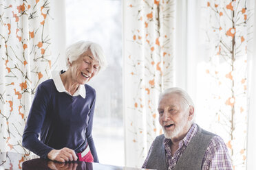 Senior man playing piano while woman singing in nursing home - MASF08941