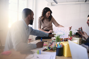 Multi-ethnische männliche und weibliche Ingenieure diskutieren über ein Diagramm am Tisch während einer Besprechung im Büro - MASF08963