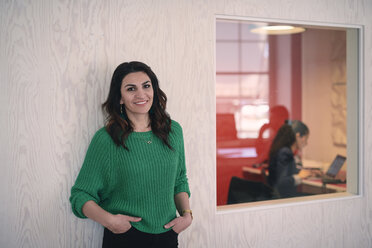 Portrait of confident mature female engineer standing with hands in pockets against wall - MASF08970