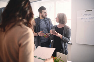 Male engineer discussing with female colleague during meeting in office - MASF09008