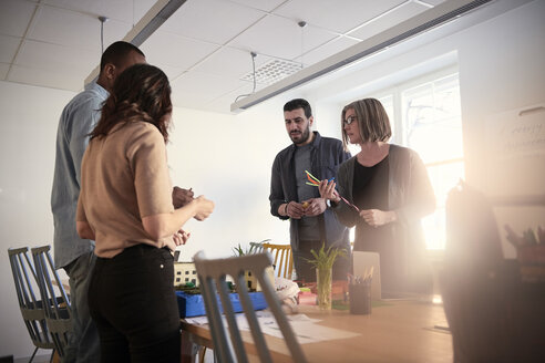 Männliche und weibliche Ingenieure stehen am Tisch und arbeiten gemeinsam an einem Projekt im Büro - MASF09010