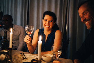 Glückliche Frau genießt das Abendessen mit männlichen Freunden auf einer Party zu Hause - MASF09034