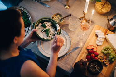 High angle view of woman having food at dining table in dinner party - MASF09037